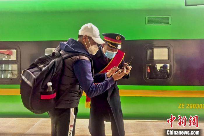 圖為日喀則火車站工作人員服務(wù)乘客?！《飞降?攝