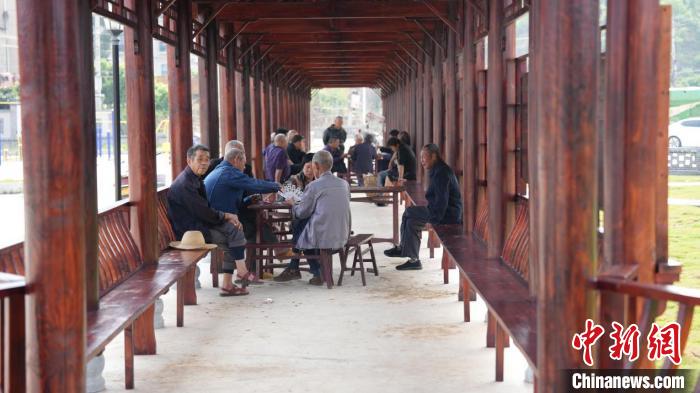 村民在由“空心房”變身而來(lái)的美麗屋場(chǎng)娛樂(lè)休閑。　何平 攝