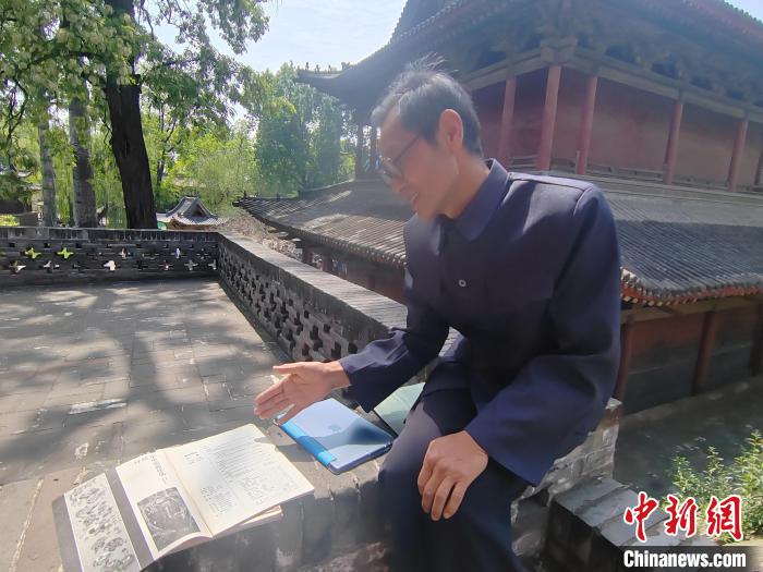 圖為王永先向記者介紹其發(fā)表在雜志期刊上的文章?！「哂昵?攝