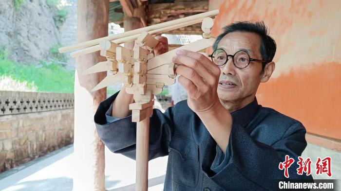 圖為王永先和他的自制斗拱模型?！∈茉L者供圖