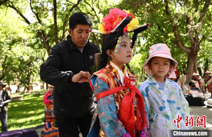 圖為上臺(tái)前，其美卓嘎的父親為她整理演出服?！≮w朗 攝