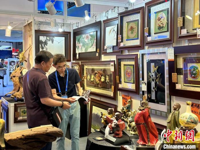 葉國鐘(右)向觀展者介紹臺灣藝術(shù)品?！》絺ケ?攝