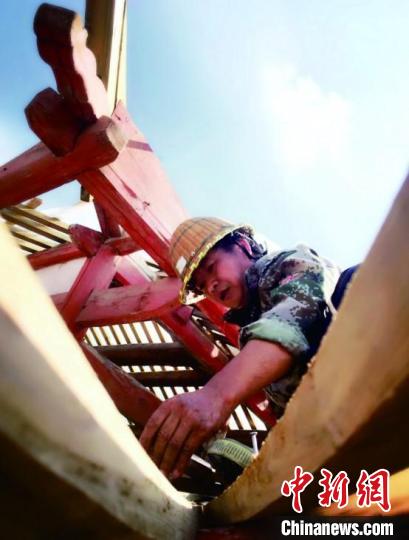 資料圖為造橋師傅進(jìn)行挑梁安裝?！↓徑?攝