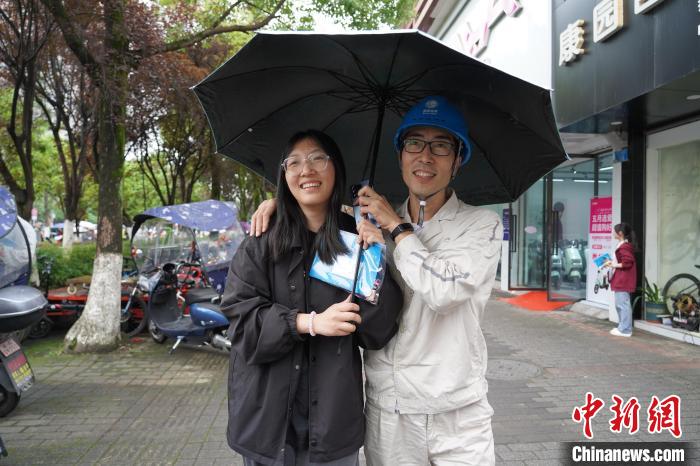 圖為楊功書(shū)(右一)準(zhǔn)備送女兒進(jìn)考場(chǎng)?！“惨?攝