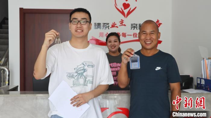 圖為剛剛拿到鑰匙的青年?！∴崢?shù)平 攝