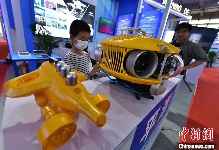 圖為展館內(nèi)水下機(jī)器人設(shè)備吸引參觀者?！埍?攝