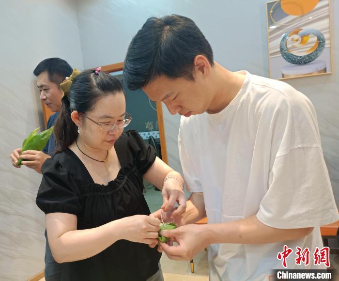 圖為臺(tái)青吳攸在學(xué)習(xí)包粽子?！∏褫W軻 攝