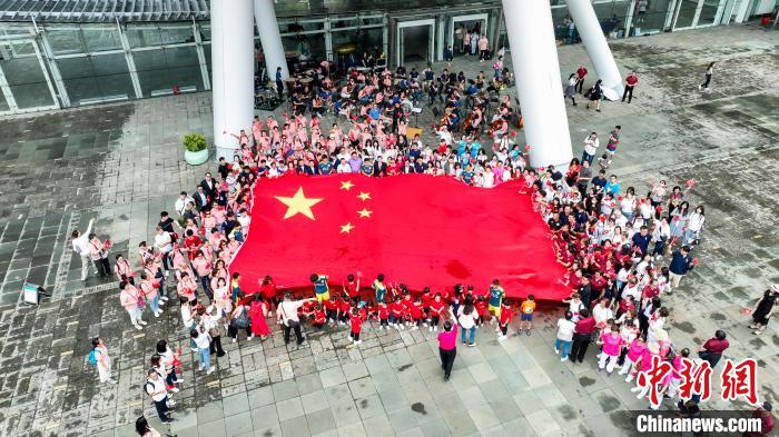 出席快閃音樂(lè)會(huì)人士拉起五星紅旗合影?！≈鬓k方 攝