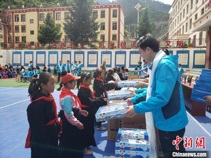 圖為公司員工代表給甘南州迭部縣多兒鄉(xiāng)中心小學(xué)的孩子們分發(fā)文具用品。(資料圖) 馬建斌 攝
