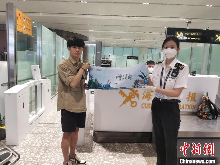 圖為大興機(jī)場(chǎng)海關(guān)對(duì)入境旅客進(jìn)行禁毒知識(shí)宣傳?！±钌袧?攝