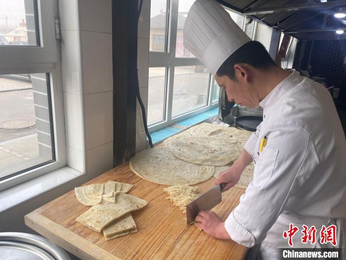 陳經(jīng)偉將餅切成長(zhǎng)條備用。　楊靜 攝