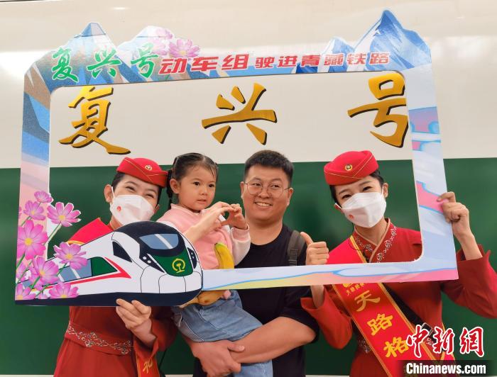 7月1日，旅客在西寧車(chē)站與“復(fù)興號(hào)”紀(jì)念牌合影留念。中新社記者 祁增蓓 攝