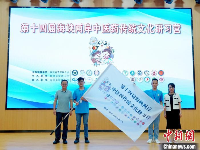 共青團(tuán)福建省委副書(shū)記吳雪(右一)、福建中醫(yī)藥大學(xué)黨委副書(shū)記林羽(左一)為兩岸學(xué)生代表頒授營(yíng)旗?！≡S燁婷 攝