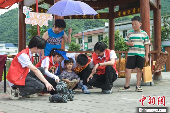 圖為學(xué)子們指導(dǎo)小朋友使用機器人。　陳一鳴 攝