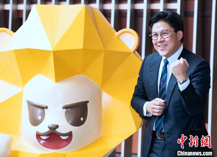 7月5日，香港立法會議員等在立法會綜合大樓為即將出征杭州2022年第19屆亞運會的中國香港代表團加油打氣。圖為立法會議員、中國香港體育協(xié)會暨奧委會副會長、本屆亞運會中國香港代表團團長霍啟剛在代表團吉祥物獅子“堅仔”旁為運動員加油。 <a target='_blank' href='/'>中新社</a>記者 侯宇 攝