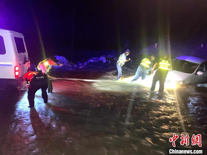 圖為民警幫助車輛安裝救援繩?！埩?攝