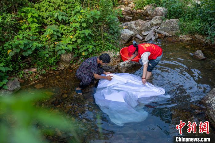 老人和義工一起洗幕布。　章毅 攝