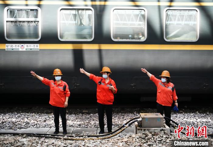 7月6日，在南昌車站，為到達(dá)的列車加滿清水后，上水工胡飛英和工友們比劃手勢(shì)準(zhǔn)備通過(guò)軌道上站臺(tái)?！『鷩?guó)林 攝