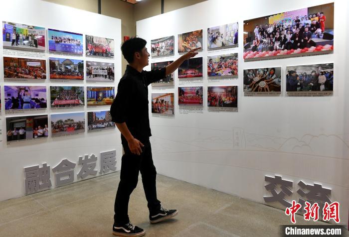 來(lái)自臺(tái)灣桃園的“80后”音樂(lè)人張家豪正在參觀圖片展?！蚊?攝