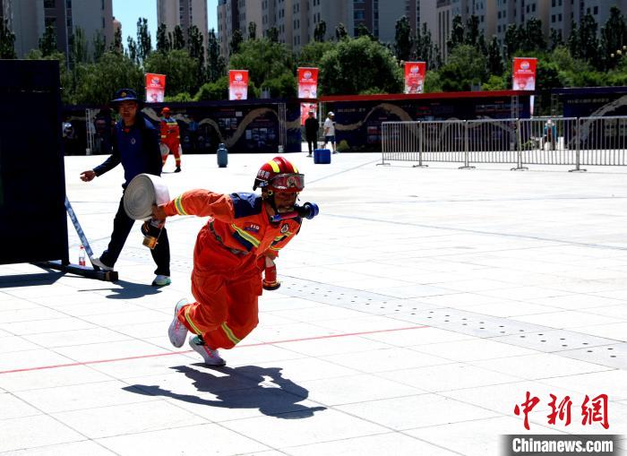 圖為參賽隊(duì)員正在進(jìn)行100米消防障礙科目競賽。　薛蒂 攝