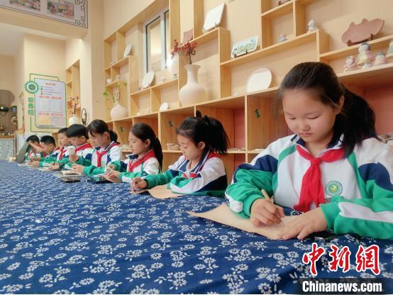 圖為康巴什區(qū)第四小學的學生在學習制作皮雕作品?！尉┕﹫D