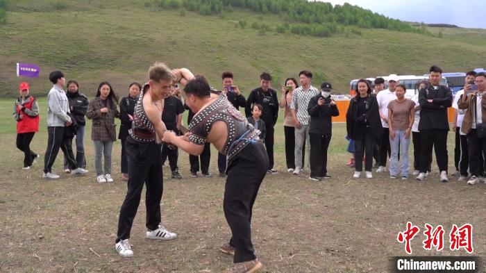 圖為大學(xué)生體驗傳統(tǒng)摔跤。　塞汗托雅 攝