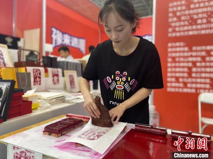 7月14日，周口華威民俗文化博物苑的講解員杜奧杰在文博會(huì)現(xiàn)場(chǎng)展示拓印。中新社記者張瑋攝