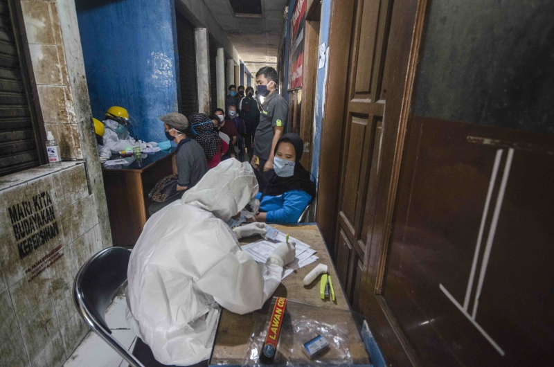 △2020年6月11日，醫(yī)務(wù)人員在印度尼西亞萬隆為人們做檢測。