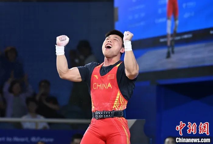 圖為諶利軍在挺舉環(huán)節(jié)試舉180公斤成功后慶祝。<a target='_blank' href='/'>中新社</a>記者 駱云飛 攝