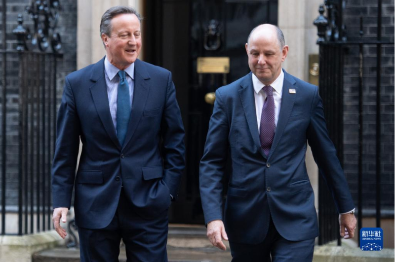 11月13日，在英國倫敦，新任外交大臣戴維·卡梅倫（左）走出唐寧街10號首相府。 新華社發(fā)