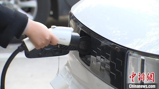 資料圖：小區(qū)居民在給新能源車充電。