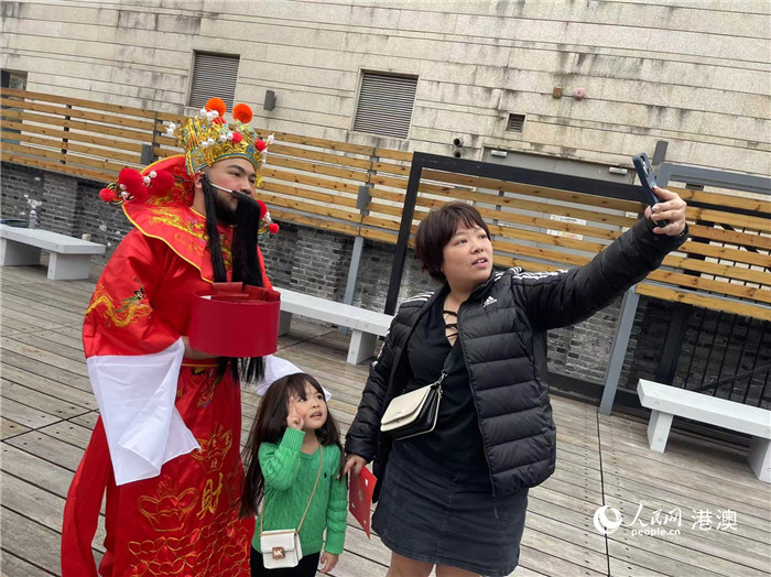 圖為送出吉祥如意的財(cái)神與游客合影。人民網(wǎng)記者 富子梅攝