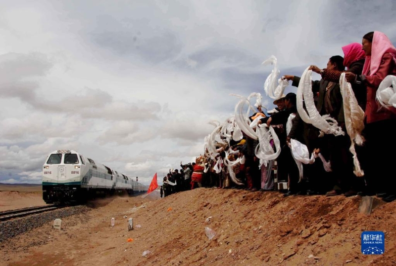 2006年7月1日，青藏鐵路全線通車，在位于青海境內(nèi)的沱沱河大橋橋頭，當(dāng)?shù)厝罕姎g迎從格爾木出發(fā)的“青1”次列車。（圖源：新華網(wǎng)）
