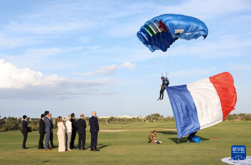 6月13日，在意大利南部普利亞大區(qū)法薩諾市，七國集團與會領(lǐng)導人觀看高空跳傘表演。（圖源：新華社）
