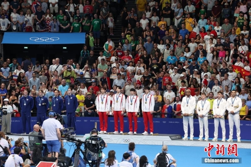 當(dāng)?shù)貢r間8月4日，在巴黎奧運會游泳項目男子4x100米混合泳接力決賽中，由徐嘉余、覃海洋、孫佳俊、潘展樂組成的中國隊奪得金牌。圖為中國隊（中）在頒獎儀式上。 