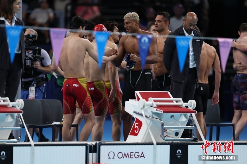 當(dāng)?shù)貢r間8月4日，在巴黎奧運會游泳項目男子4x100米混合泳接力決賽中，由徐嘉余、覃海洋、孫佳俊、潘展樂組成的中國隊奪得金牌。圖為場上運動員相互致意。